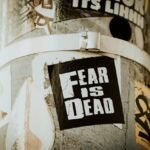A sticker that says "fear is dead"